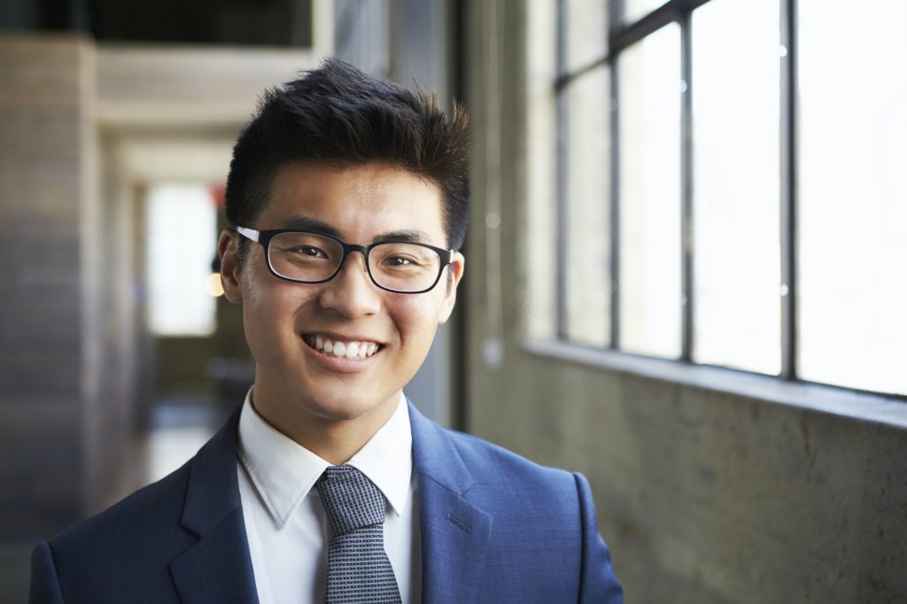 Young Asian businessman smiling to camera